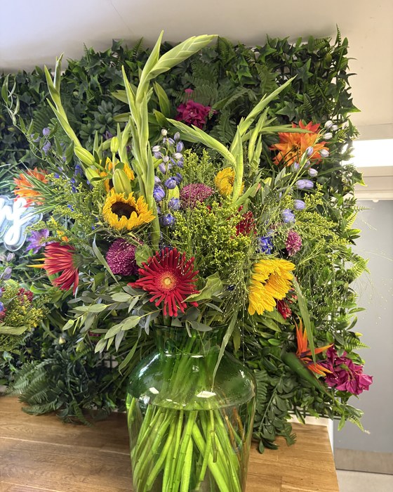 Tall vase arrangement with sunflowers and gerberas