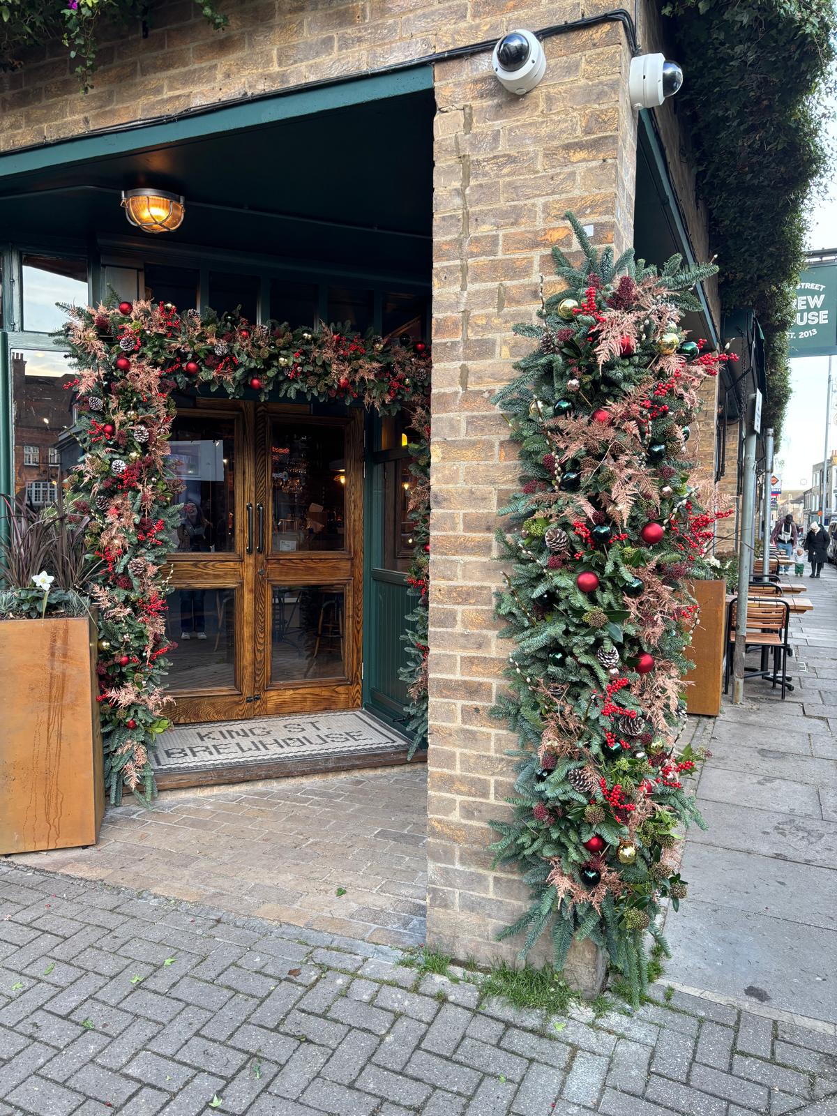 Christmas garland of spruce, foliage and baubles framing a pub entrance