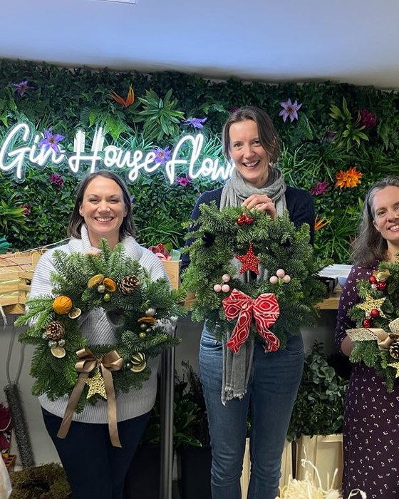 Guests with their finished Christmas wreaths in the shop