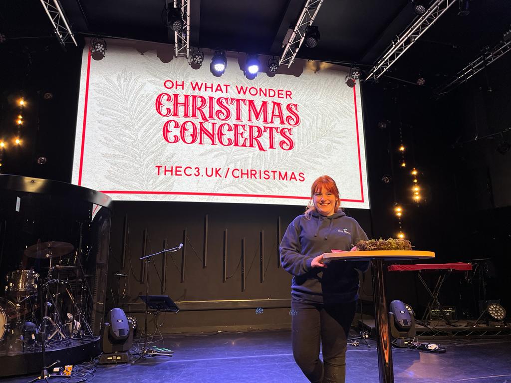 Our florist demonstrating wreath making on stage to a large group