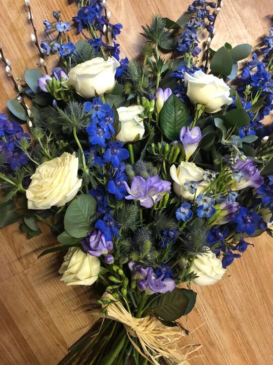 Tribute of blue delphiniums and white roses